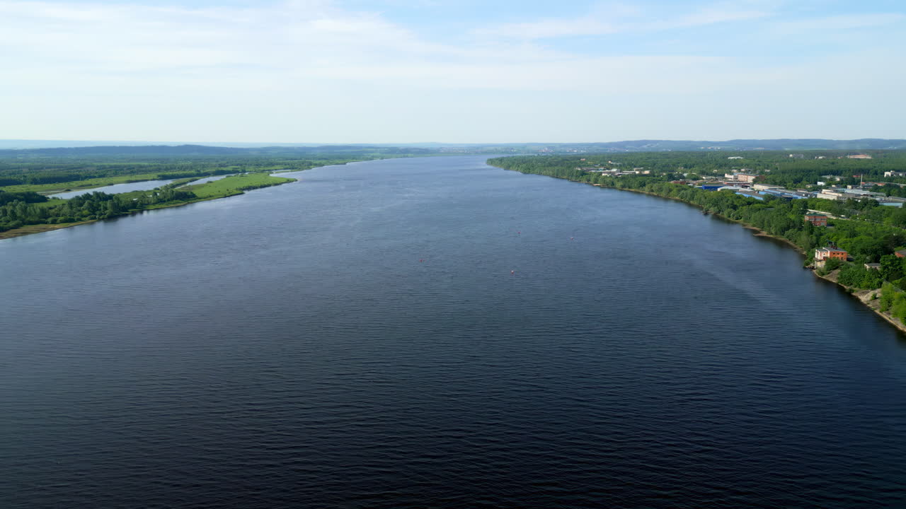 Ampio fiume che scorre attraverso un paesaggio con una città sulla riva