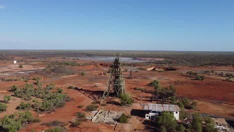 drone zooms out from the headframe to reveal a bleak, industrial wasteland