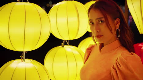 Slow-motion-portrait-of-beautiful-Vietnamese-woman-in-traditional-dress-smiling-with-yellow-lanterns