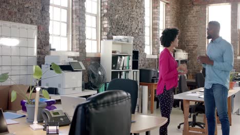 happy diverse colleagues discussing work and drinking coffee in office in slow motion