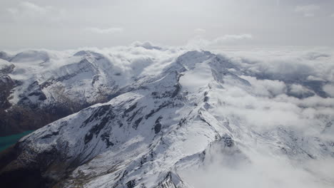 Cinematic-aerial-panoramic-Shot-of-white-snowy-mountains-during-sunlight---Austrian-Alps,Europe