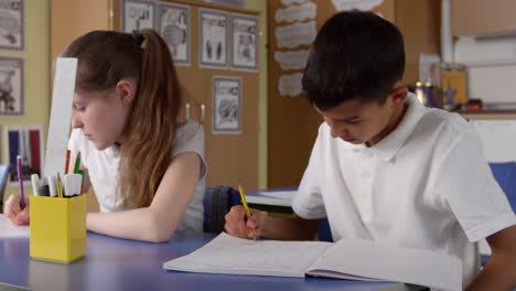 primer plano de los alumnos que trabajan en los escritorios en el aula filmado en r3d