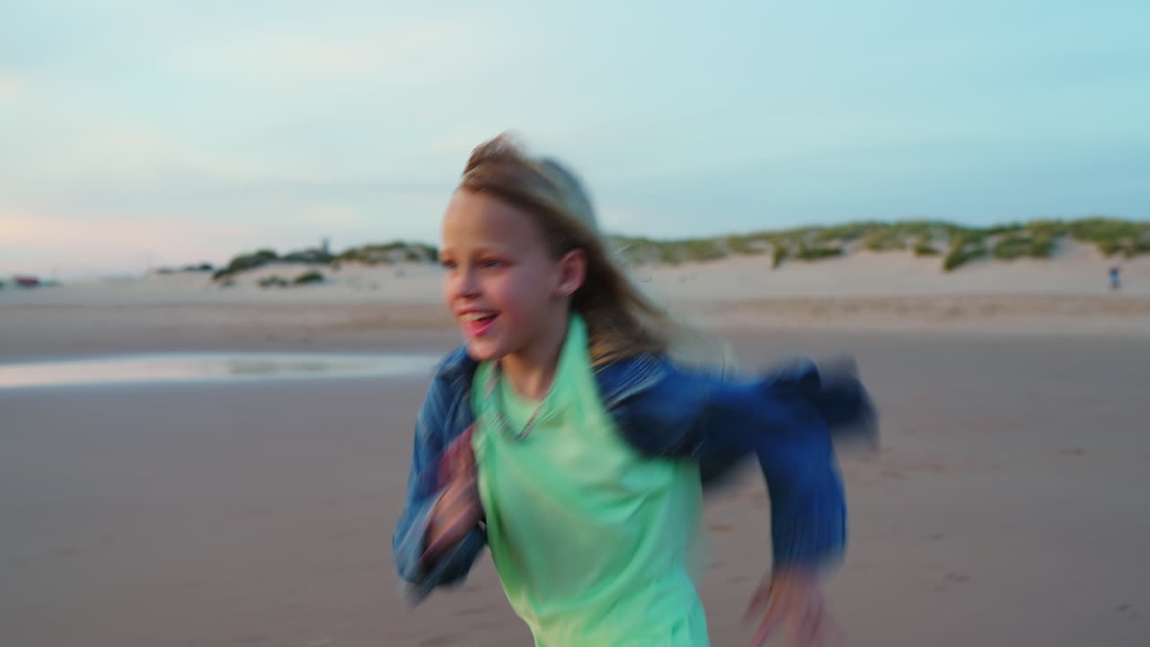 Happy Young Girl Running and Playing on a Sandy Beach