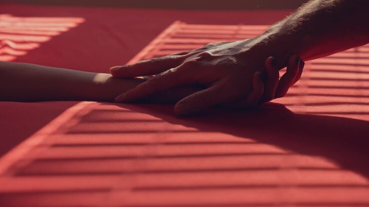 Hands touching on the bed