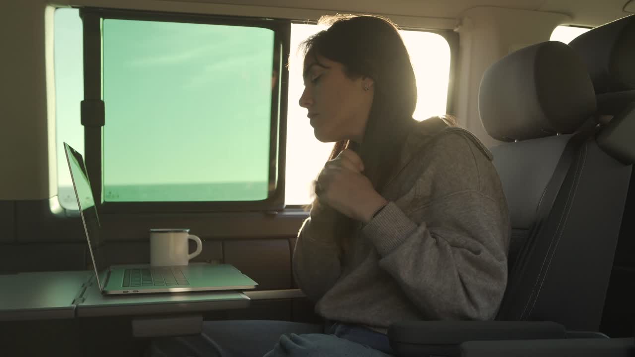 mujer viajera trabajando en una computadora portátil en una furgoneta