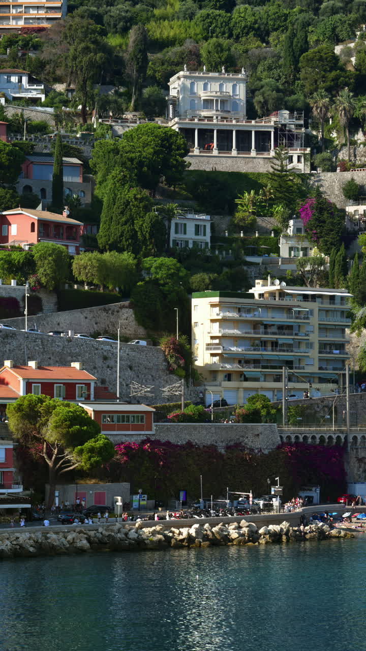 View of the beach with the buildings in Villefranche sur Mer, France on the background. Vertical