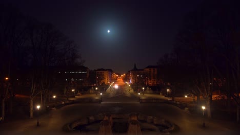 Calle-Larga-Y-Solitaria-En-Munich-En-Tiempos-De-Corona-Y-El-Bloqueo-Covid-19-Bajo-La-Brillante-Luna-Llena-Con-Vistas-Al-Paisaje-Urbano-De-La-Popular-Ciudad-Bávara,-Casi-Vacía-Por-La-Noche