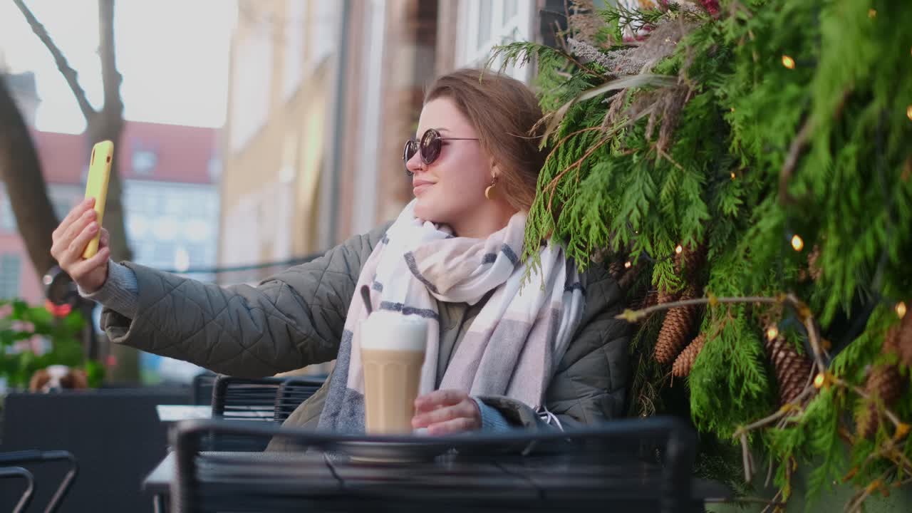 Woman taking a selfie at a cafe