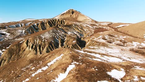 snowy mountain landscape with eroded hills