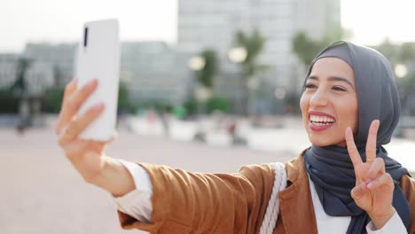 young woman in hijab taking playful and joyful selfies outdoors