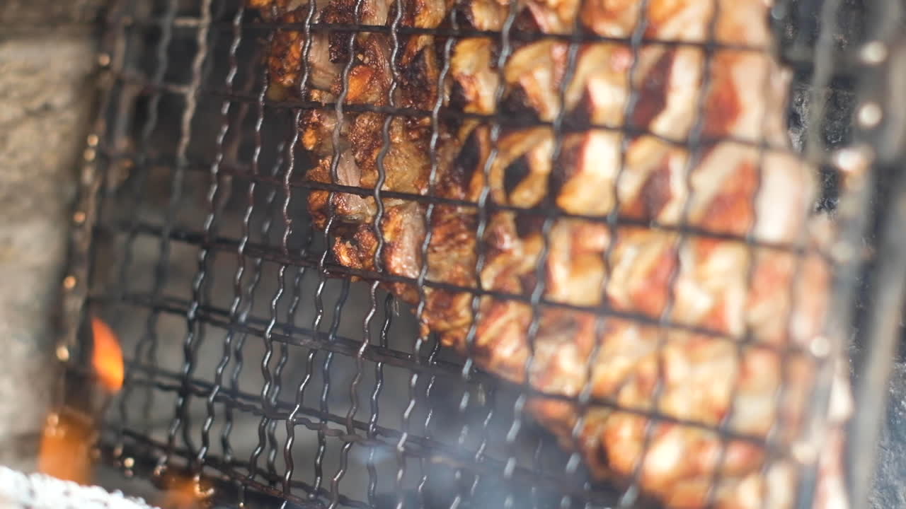 지방이 뚝뚝 떨어지는 그리드의 육즙이 많은 양 갈비 - 장작불 옆에 있는 바비큐