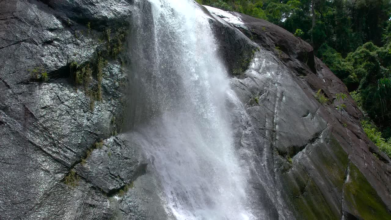 toma cercana de la corriente de salpicaduras en la cascada telaga tujuh en las montañas rocosas de langkawi, malasia