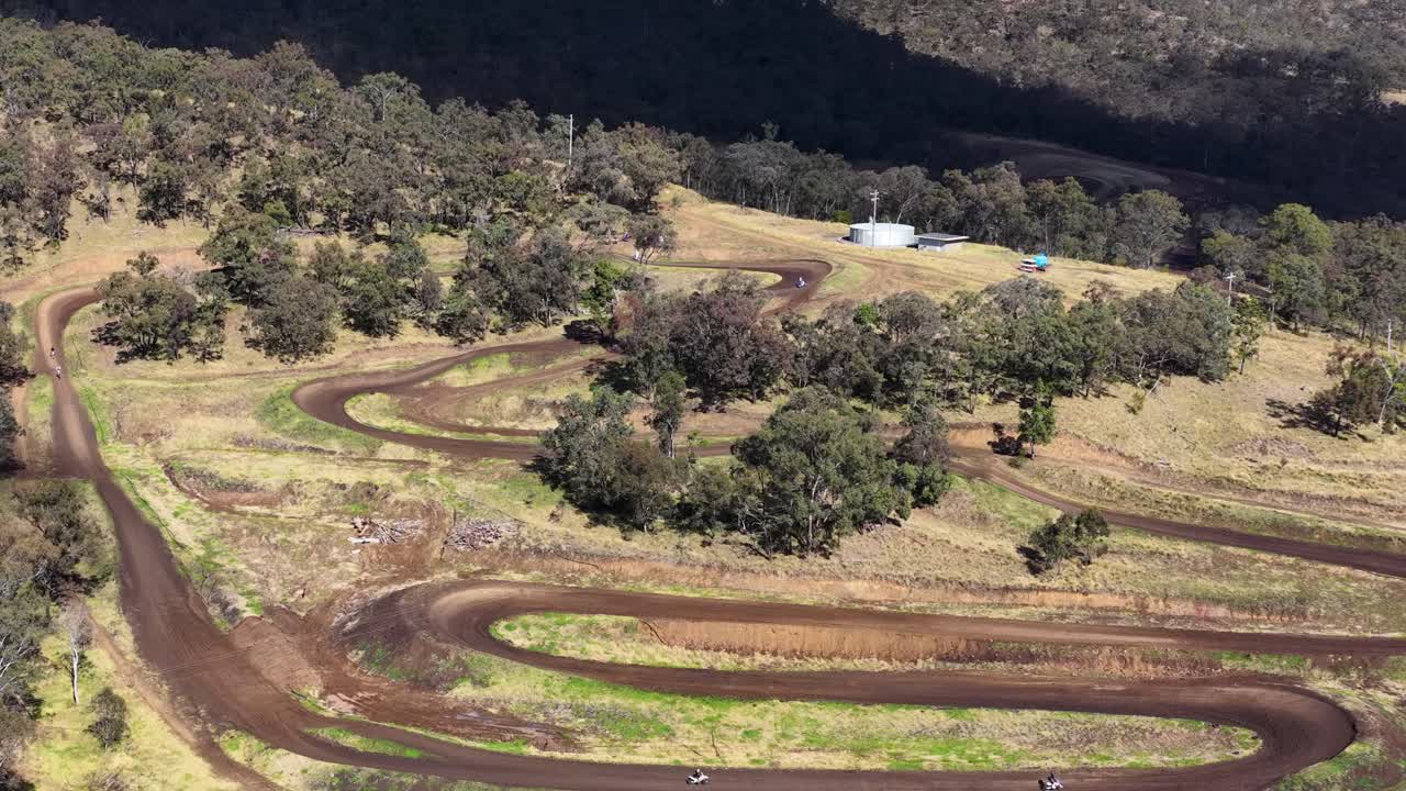 Aerial view of motorbike racing on winding dirt track