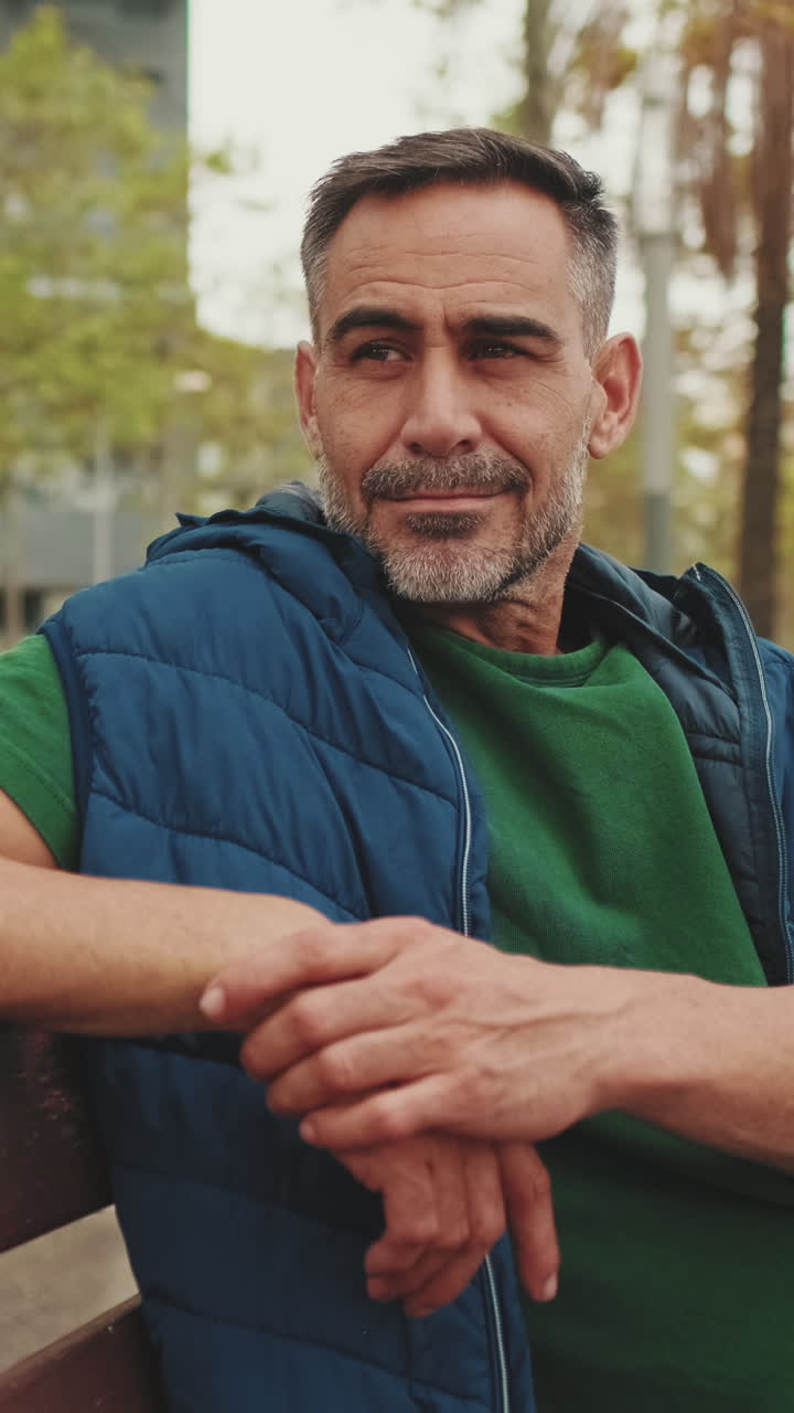 Middle-aged man sitting on a bench in a city park