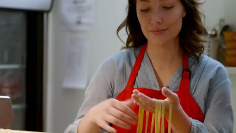 female baker arranging pasta on pasta rack 4k