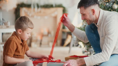 father and son unpacking christmas present together