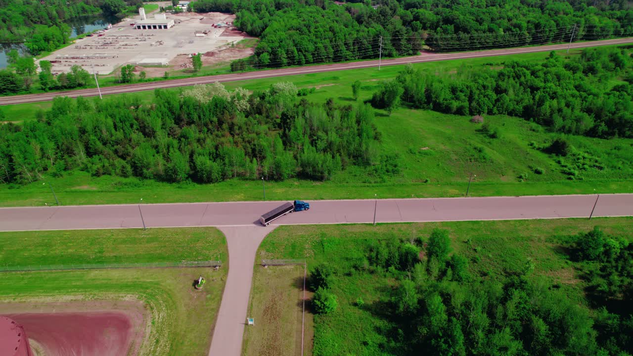 camión azul con remolque de tolva girando a la derecha