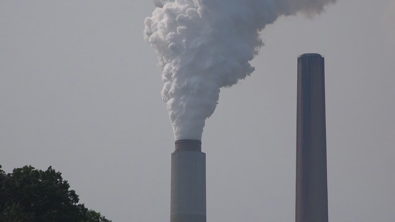 las chimeneas industriales arrojan contaminación a la atmósfera liberando gases de efecto invernadero y contribuyendo al calentamiento global