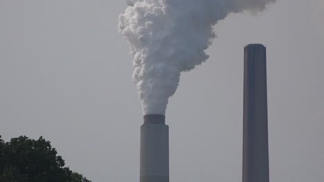 industrial smokestacks belch pollution into the atmosphere releasing greenhouse gas and contributing to global warming