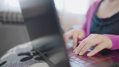 a close-up woman sitting on a sofa press to type information computer laptop for shopping online at home