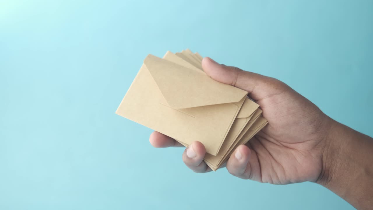 갈색 봉투 한 어리를 들고 있는 손