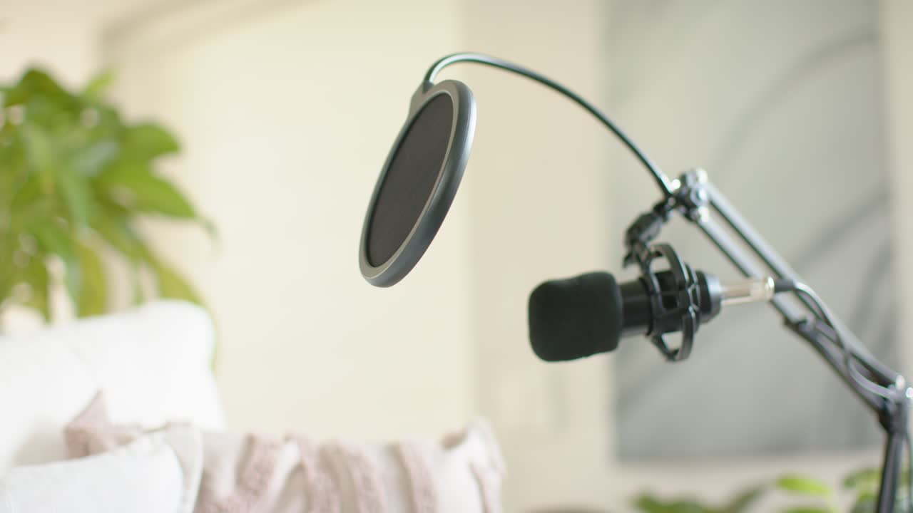 Arm is pivoting after adjustment, bringing mic with pop filter closer in home studio to record