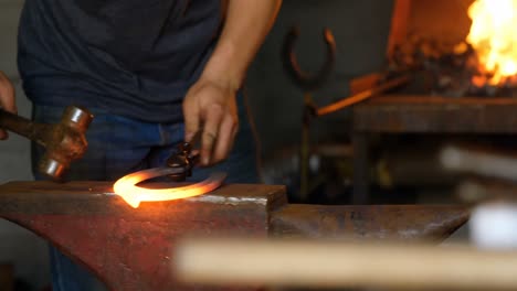 female metalsmith molding horseshoe in factory 4k