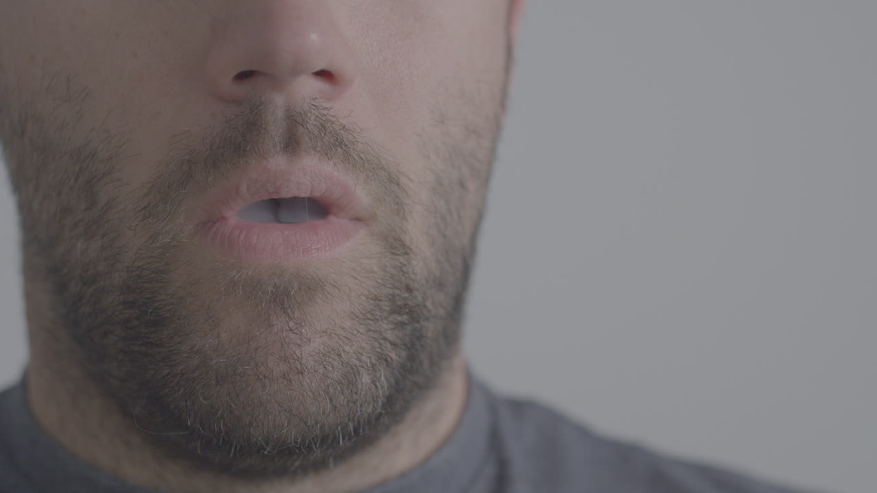 un hombre que usa una pluma de vape que inhala cannabis con nicotina o cbd con sabor