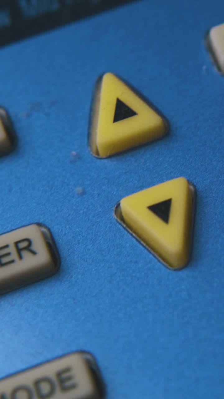person presses rubber buttons with marks on used air conditioner remote control extreme close view