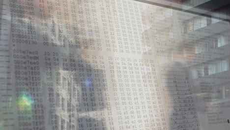 binary code animation overlaying people working in office building