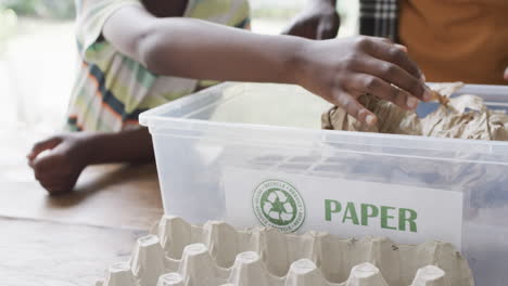un niño afroamericano aprende sobre el reciclaje en casa