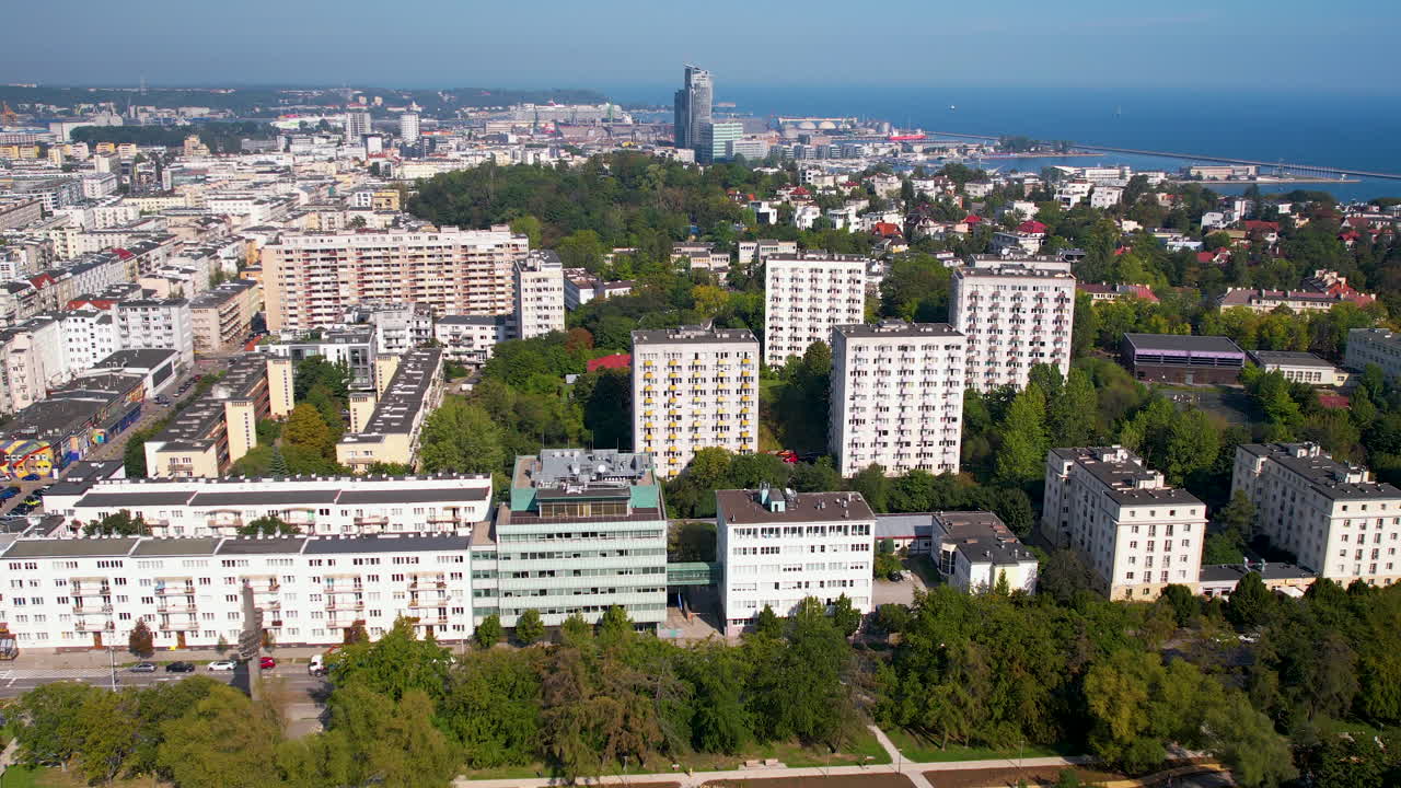 Aerial view of downtown Gdynia's Park Centralny, spotting the Sea Towers and the clear blue Baltic Sea on the horizon