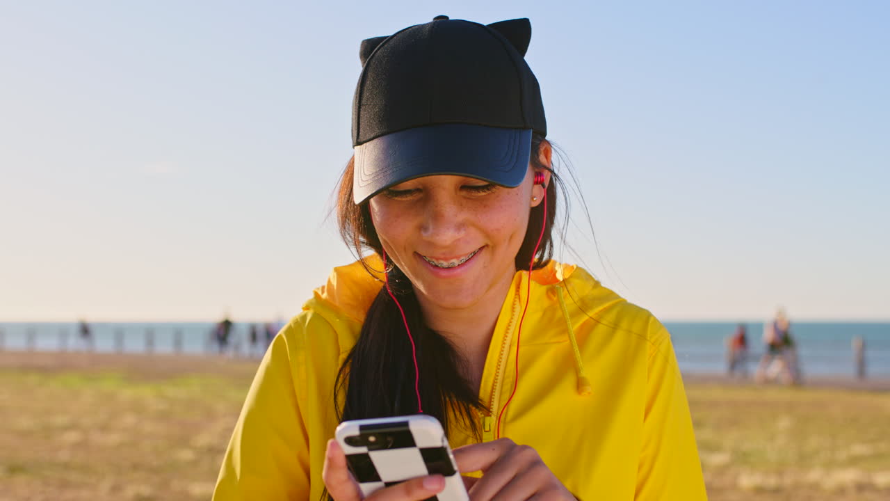 chica adolescente usando el teléfono en la playa