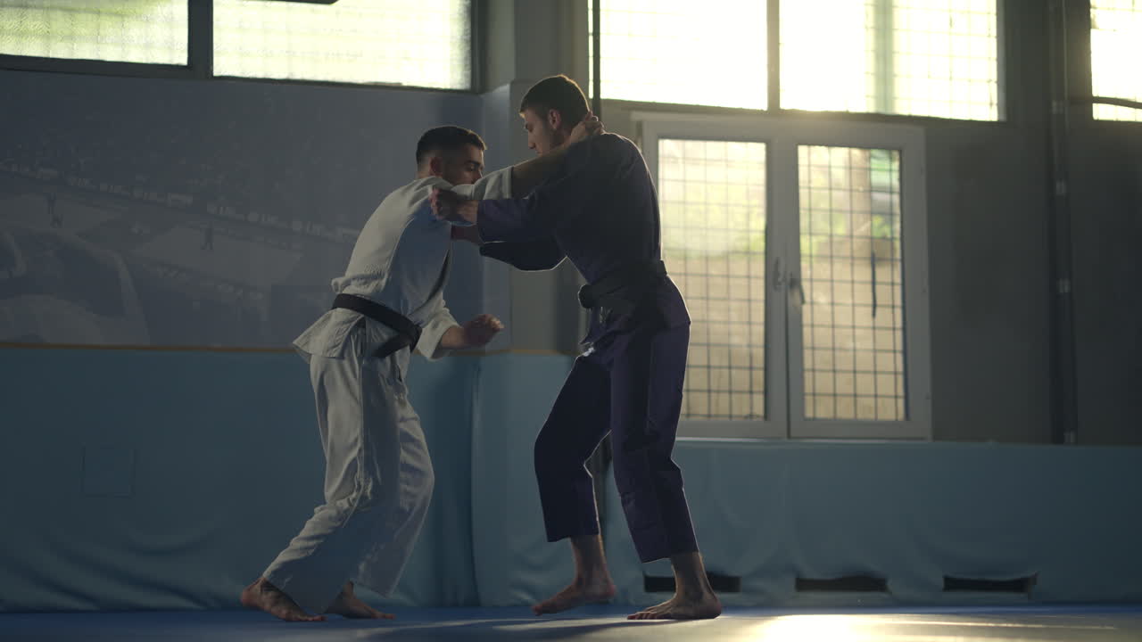 Two Martial Artists Practicing Judo in a Gym