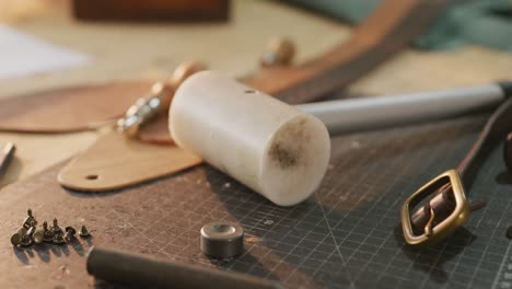 close up of diverse tools lying on table in leather workshop