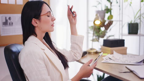 Pensive-Enterprising-Businesswoman-Browsing-Social-Media-on-Smartphone