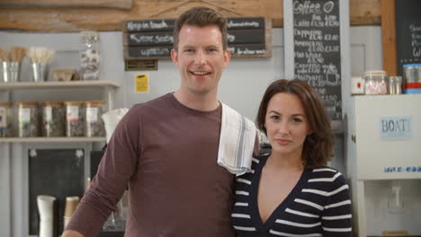 Smiling-cafe-owners-behind-the-counter-of-their-business,-shot-on-R3D