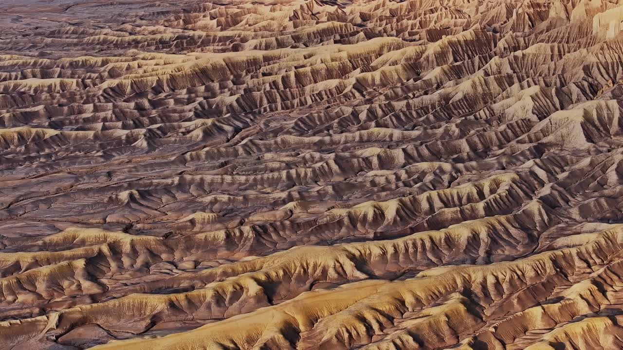Cresta di calanchi desertici stratificati e modelli di erosione in terreno arido vicino a Factory Butte Utah, drone