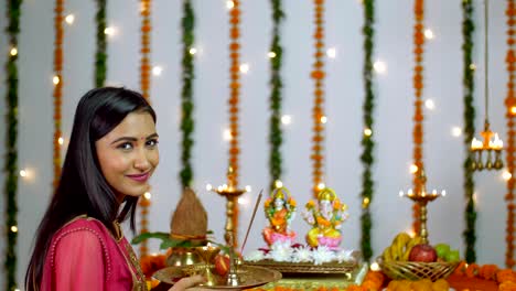 a young attractive woman in front of lord ganesha and goddess lakshmi on diwali