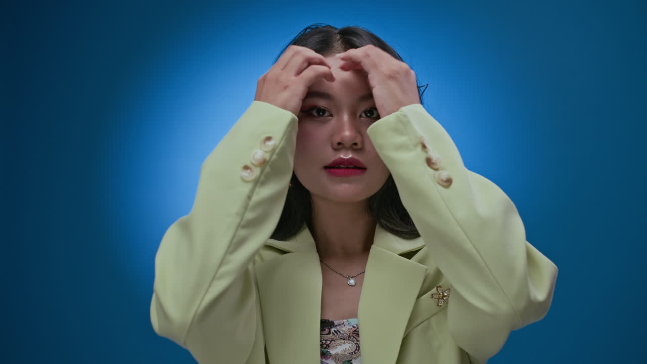 Portrait of Gen Z Asian Girl Posing for Camera Isolated on Neon Blue
