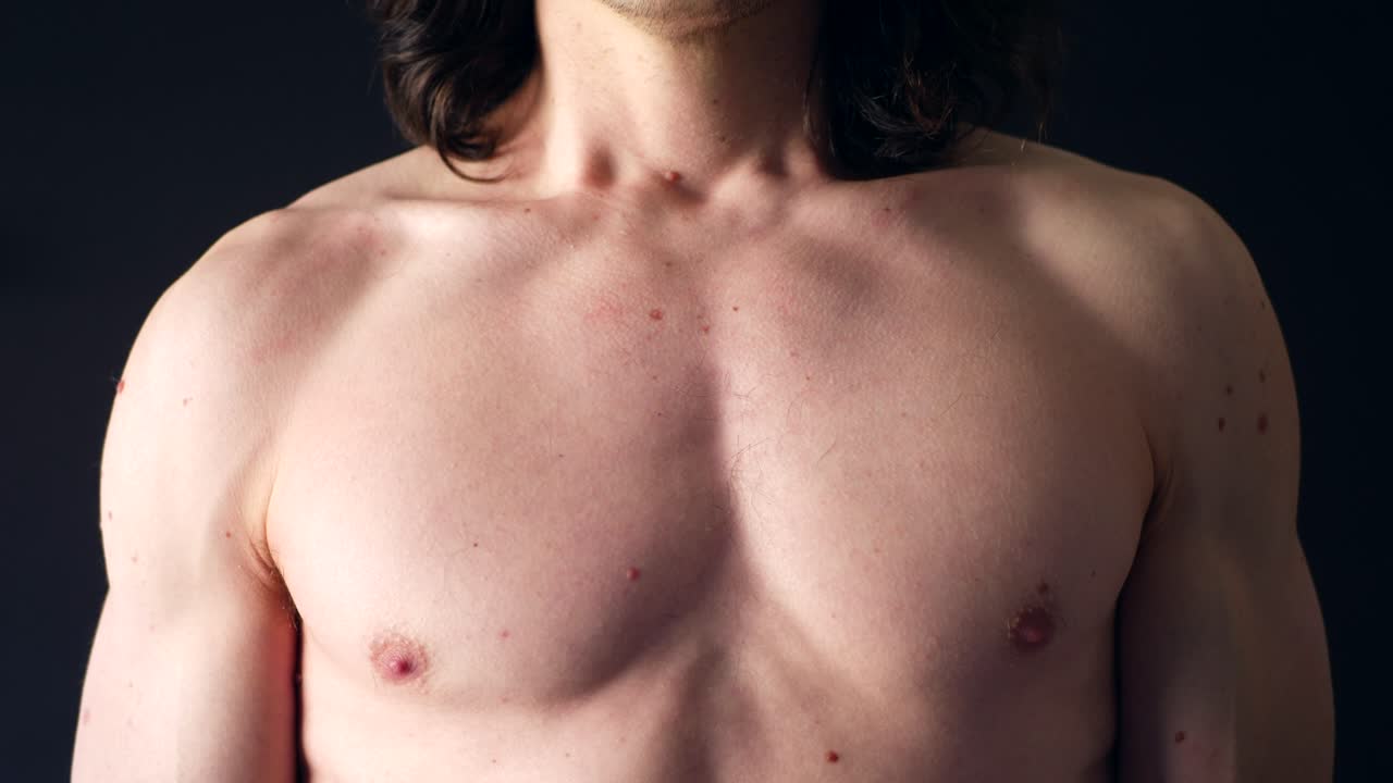 un hombre blanco fuerte y sin camisa respirando profundamente en su pecho después de un entrenamiento corporal a cámara lenta