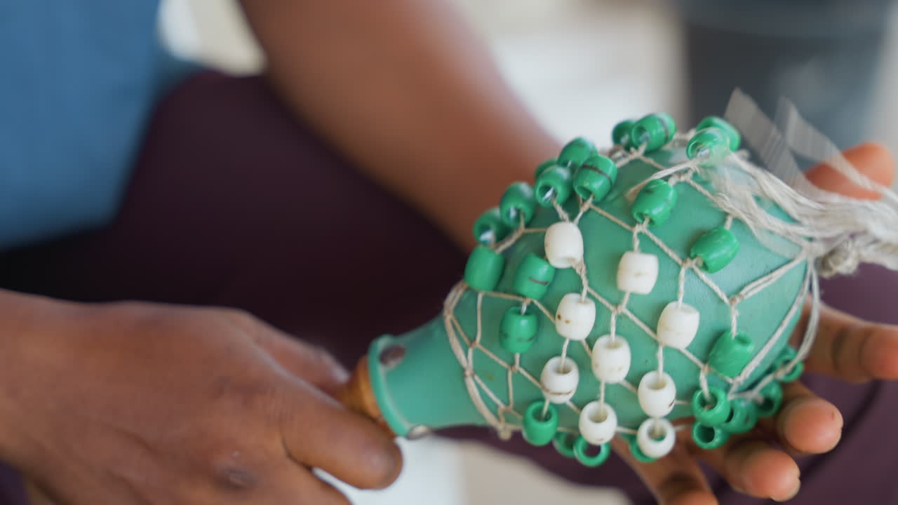 Hands presenting cleaned beaded scrubber, final stage of house chore, handheld green brush with bead net, palms dusted with residue, gentle twist to remove debris, warm home light, content mood