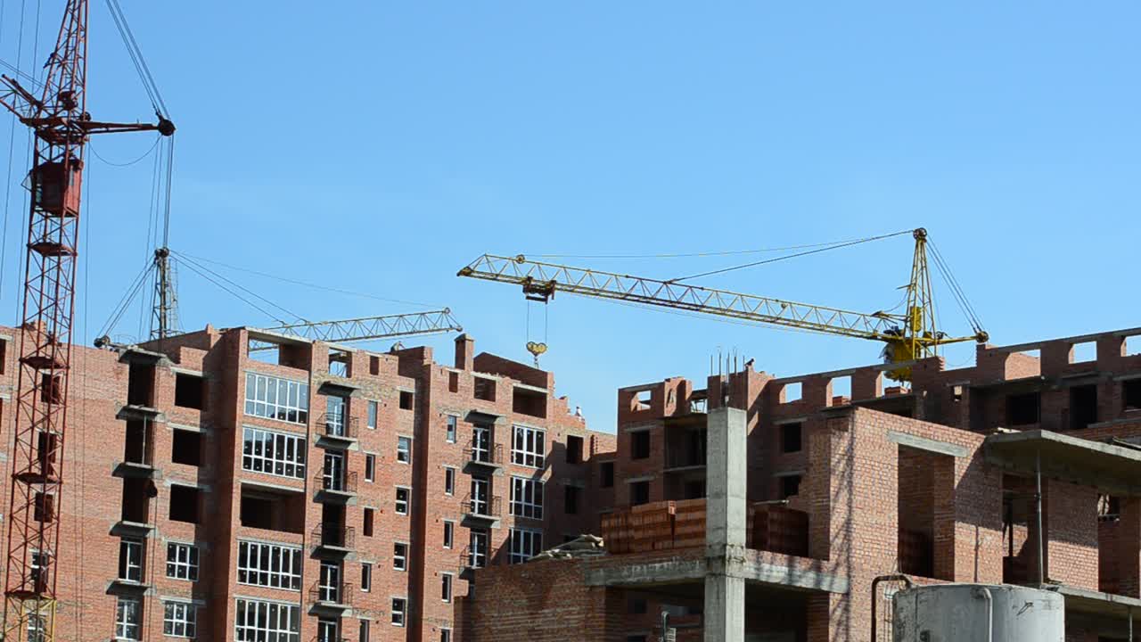 Gru edili sopra le case. Costruzione di edifici residenziali