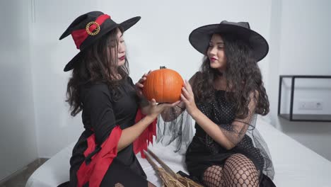 two witches with a pumpkin