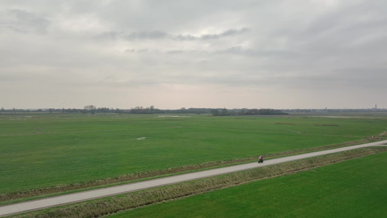 시골을 통해 빈 도로를 타고 스쿠터 라이더