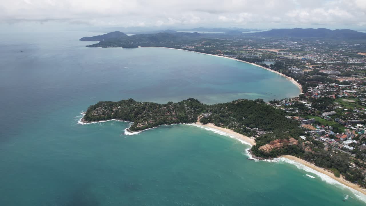 Aerial flight over the coast of Phuket island in Thailand. Flight over the Surin beach, Pansea beach at Baan Thai Choeng Thalay during the sunny day with clouds in the sky in May 2025