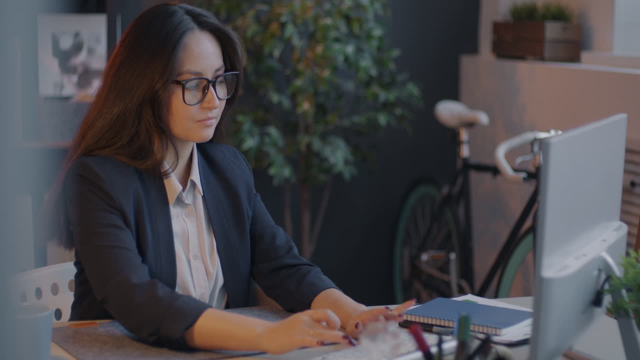 mujer trabajando en computadora en una oficina moderna