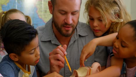 Vielfältige-Gruppe-Von-Schulkindern,-Die-Im-Klassenzimmer-Anatomie-Studieren,-Mit-Lehrer-Am-Schreibtisch-4K