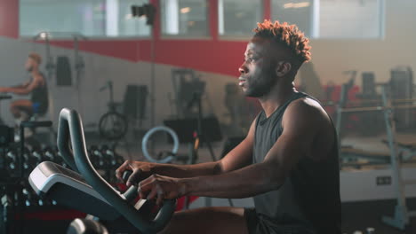 man exercising on an exercise bike in a gym