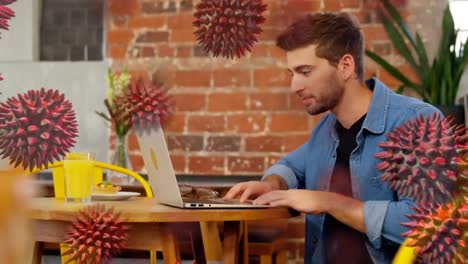hombre caucásico usando una computadora portátil sobre macro coronavirus células covid19 flotando